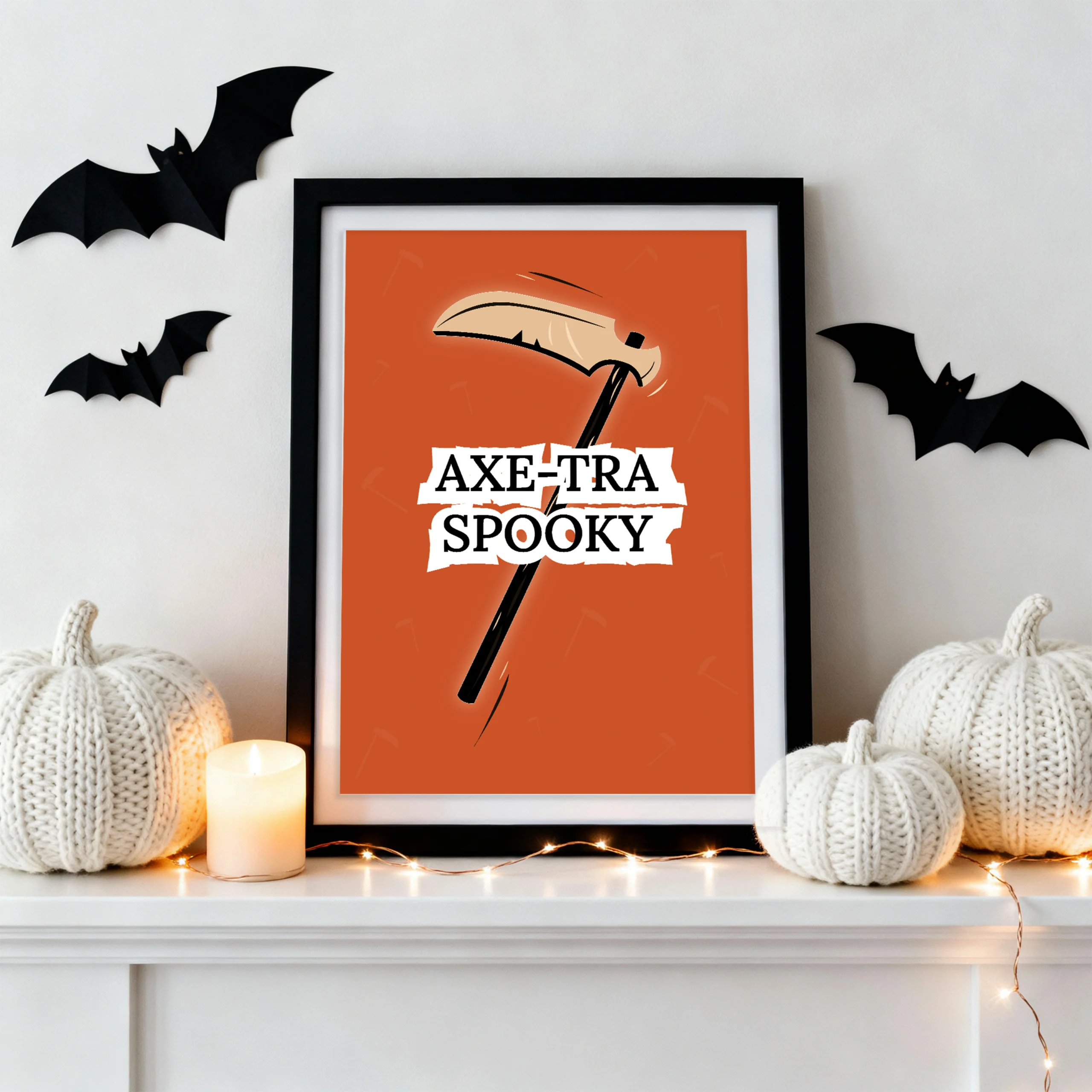 Halloween printable wall art with “Axe-Tra Spooky” scythe poster, styled with knit pumpkins, candles, and bat decor on a modern white mantel